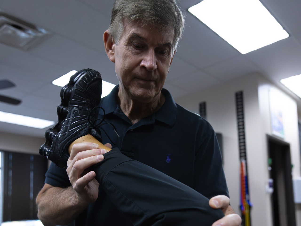 Advanced Health Solutions clinician bending a patient's knee while supporting the lower leg and foot in the therapy room