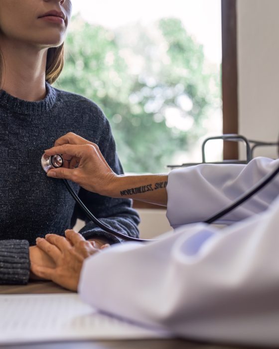 Advanced Health Solutions: doctor listening to a middle-aged patient's heartbeat