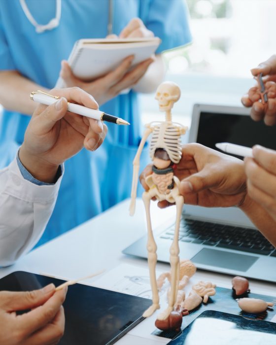Advanced Health Solutions: medical team in lab coats and scrubs meeting at a table to discuss a patient