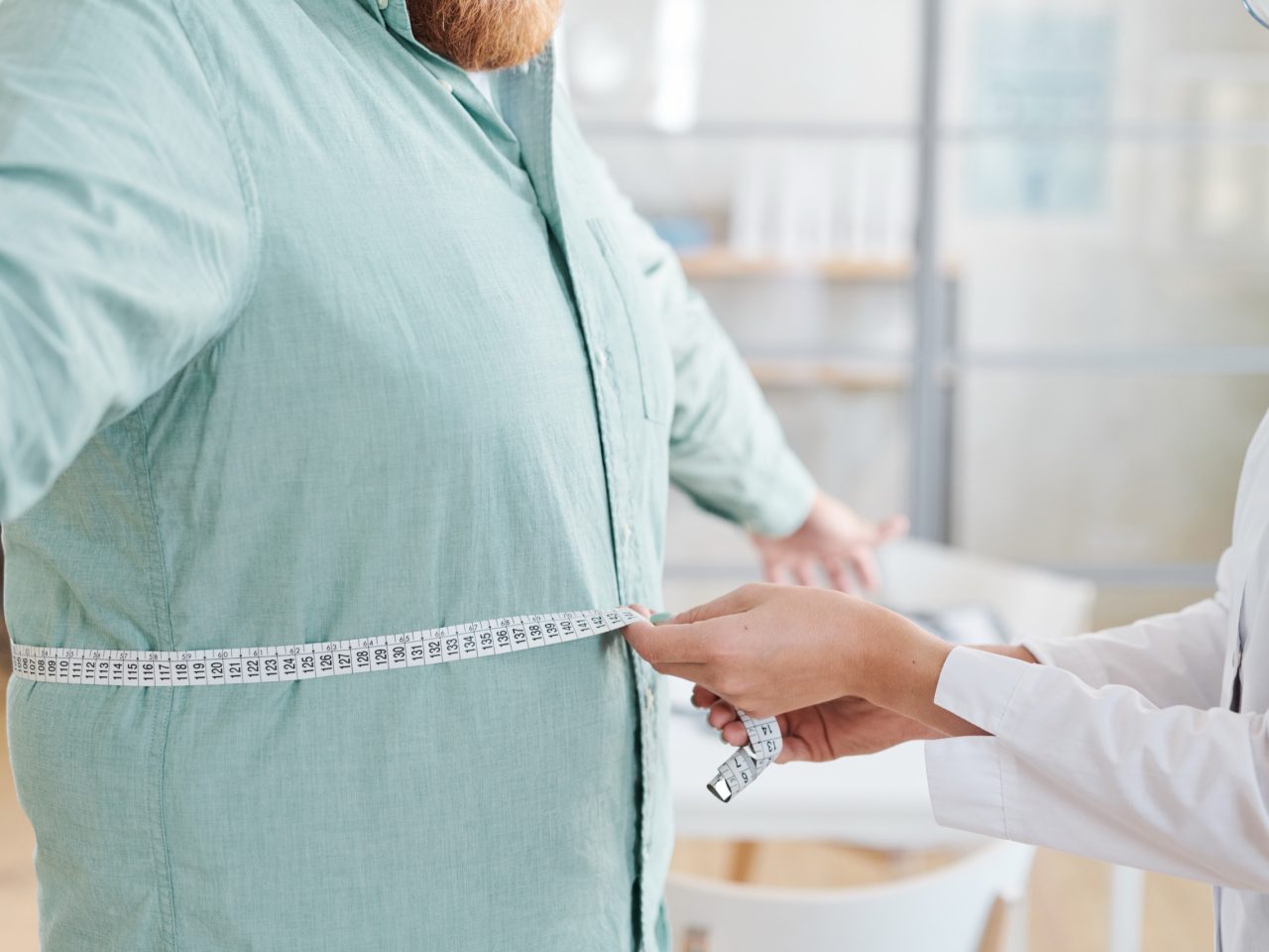 Advanced Health Solutions: close-up of a doctor measuring a man's waist